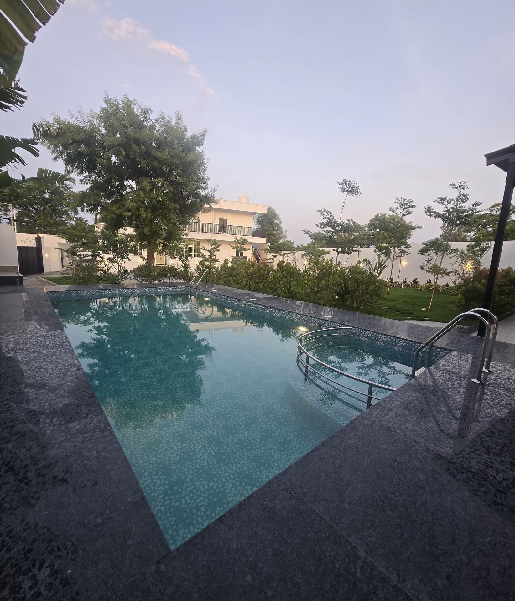 Swimming pool with the villa beyond at dusk